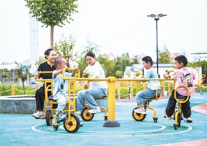 8月1日，二师体育公园内，家长带着孩子体验多人旋转脚踏车。 周静静 摄
